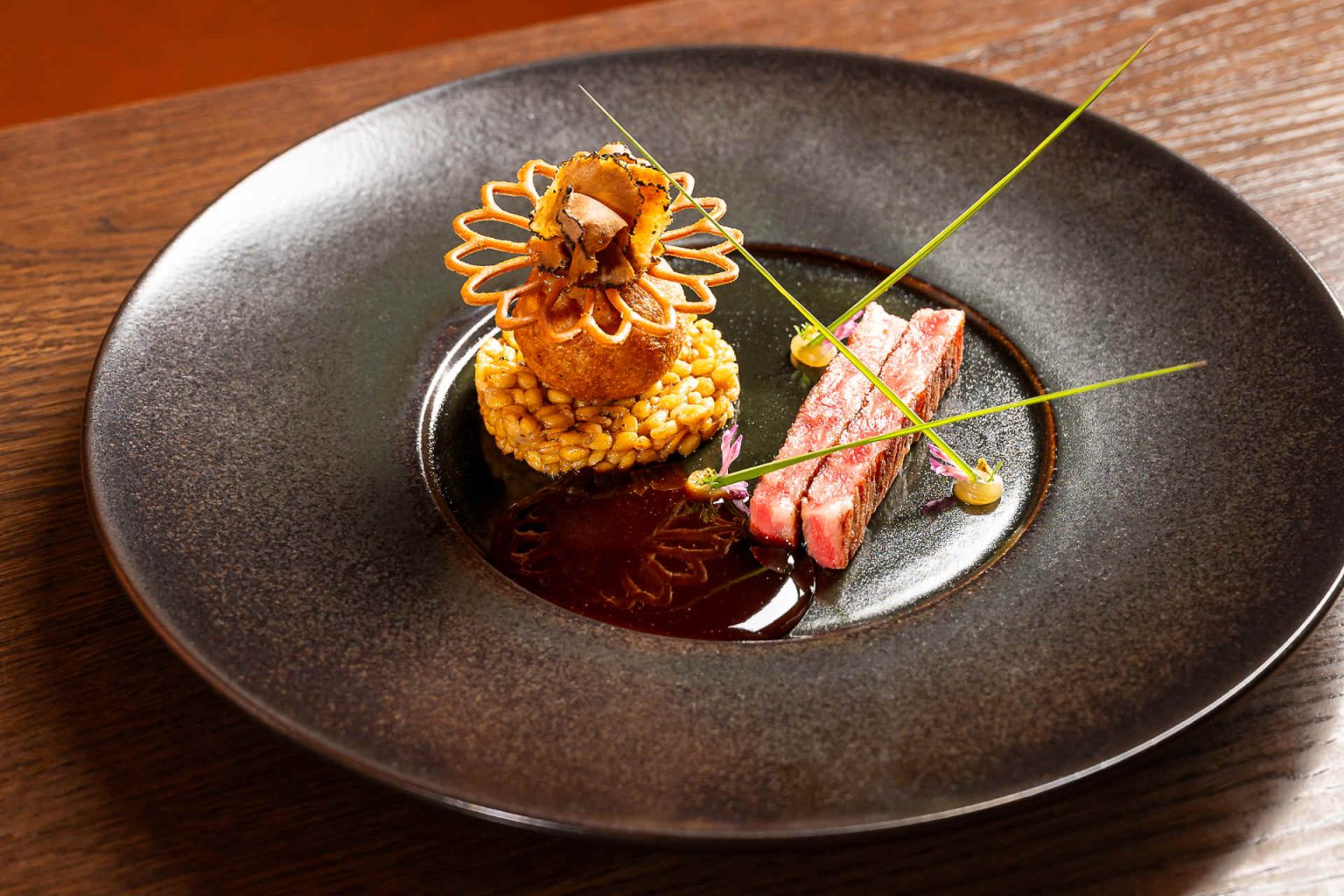 Wagyu, einkorn truffle risotto, einkorn truffle fritters, marzipan calvados gel, Szechuan buttons and clover © Claus Kadrnoschka