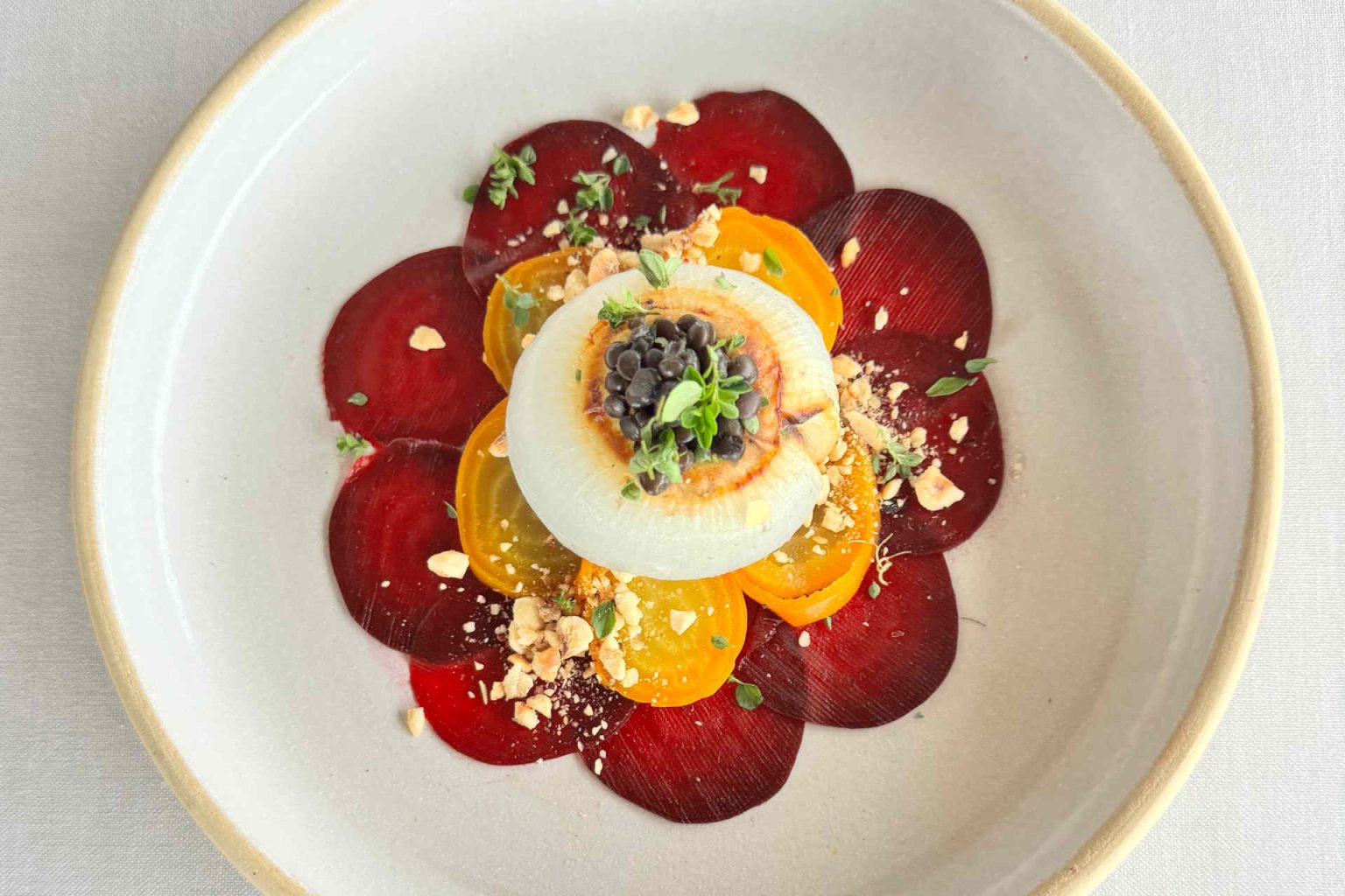 Stuffed white onion on beetroot carpaccio by Luger, photo provided