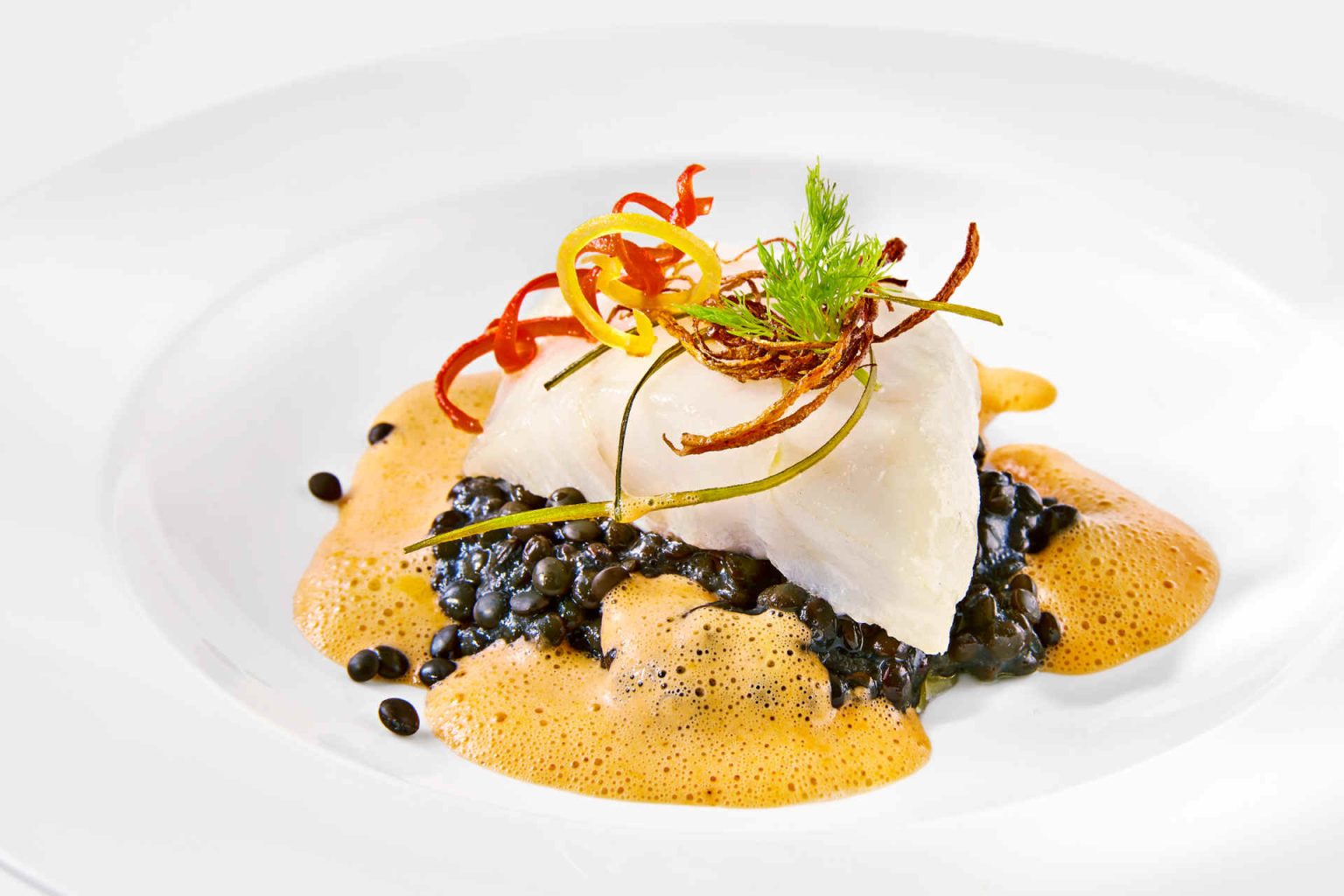 Intermediate course: Medallion of winter cod on spicy beluga lentils and paprika foam, photo provided